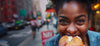 Woman eating a bagel on a city street halo bagels best bagels in nyc
