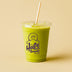 Green smoothie in a Halo Bagels Cafe cup with a straw on a beige background 