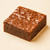 Square brownie with a cracked surface on a beige background halo bagels harlem