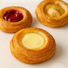 Three pastries with different fillings on a light background harlem halo bagels danishes pastries