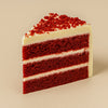 Slice of red velvet cake with cream cheese frosting on a beige background  halo bagels harlem