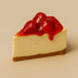 Slice of cheesecake with strawberry topping on a beige background halo bagels harlem